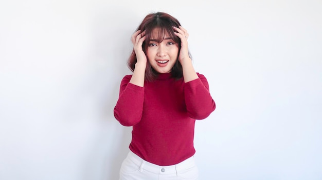 Menina asiática confusa e com medo com camisa vermelha em fundo branco
