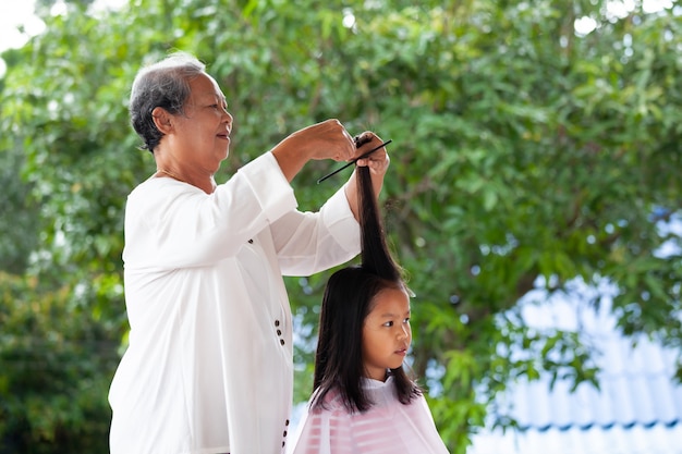 Menina asiática cortando o cabelo