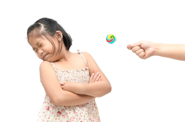 menina asiática criança com expressão de desgosto contra doces e que sofrem de dor de dente isolado na w