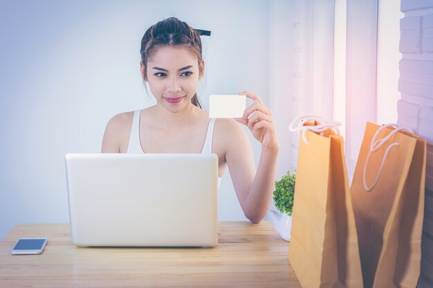 Foto menina asiática, desgastar, um, colete branco, segurando, um, cartão crédito, em, mão