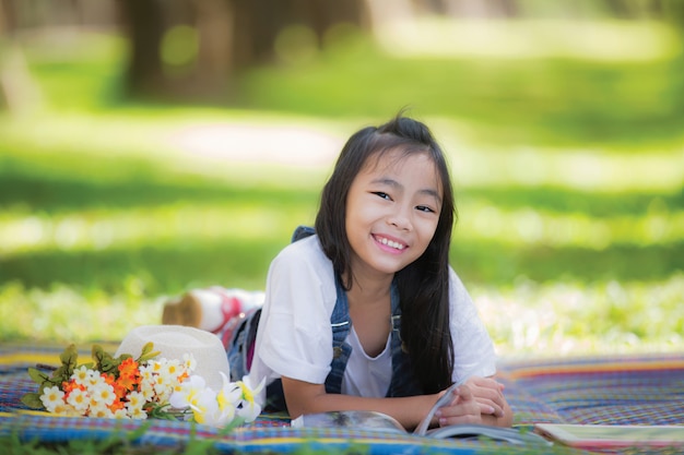 Menina asiática dormindo no jardim