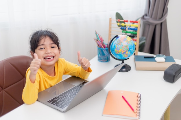 Menina asiática em casa fazendo lição de casa