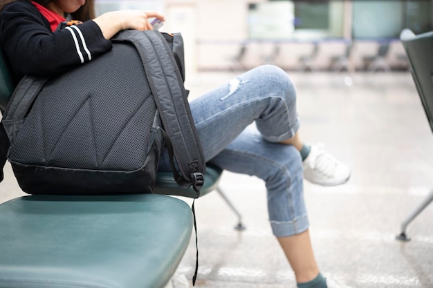 Foto menina asiática esperando a partida no aeroporto em suas férias