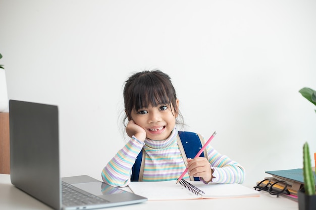 Menina asiática estudando na escola parecendo muito feliz