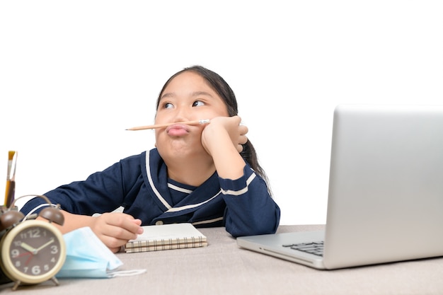 Menina asiática fazendo lição de casa no laptop