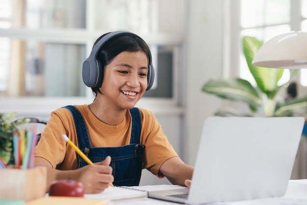 Menina asiática feliz aprendendo on-line em casa