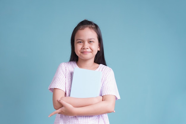 Menina asiática feliz em pé segurando o livro