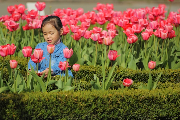 Menina asiática feliz em um campo de tulipas