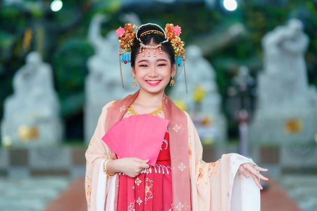 Menina asiática feliz vestindo fantasias chinesas segurando envelopes vermelhos decoração para o festival do ano novo chinês celebrando a cultura da china no santuário chinês Lugares públicos na Tailândia