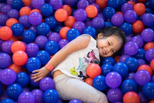 Menina asiática gosta de brincar em um parque infantil