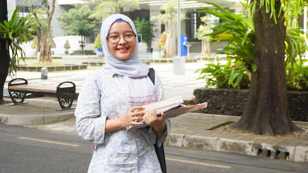 Menina asiática hijab que está estudando na universidade