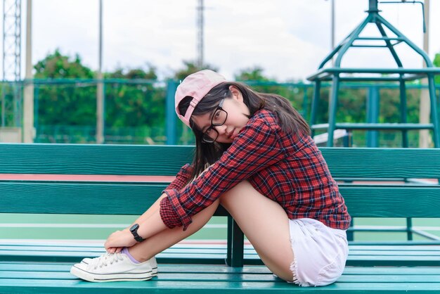 Menina asiática hipster posar para tirar uma fotoRetrato de moda mulher bonita na quadra de tênis estilo de vida da adolescente tailandesa moderna