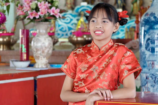 Menina asiática no vestido chinês, respeitando a deus.