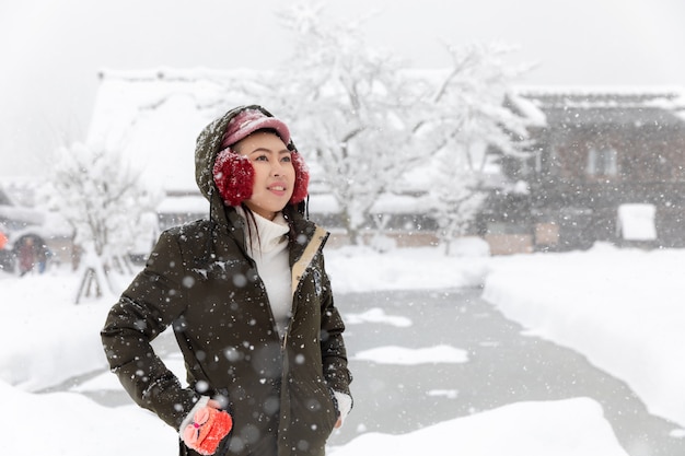 Menina asiática nova da mulher na estação da neve do inverno