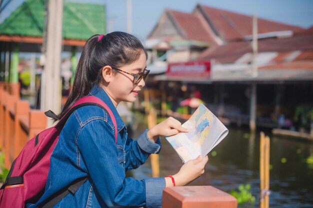 Menina asiática nova que anda no mercado de flutuação de Dumonoe saduak, Tailândia