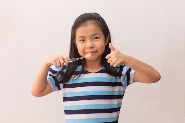 Menina asiática pequena escova de dentes