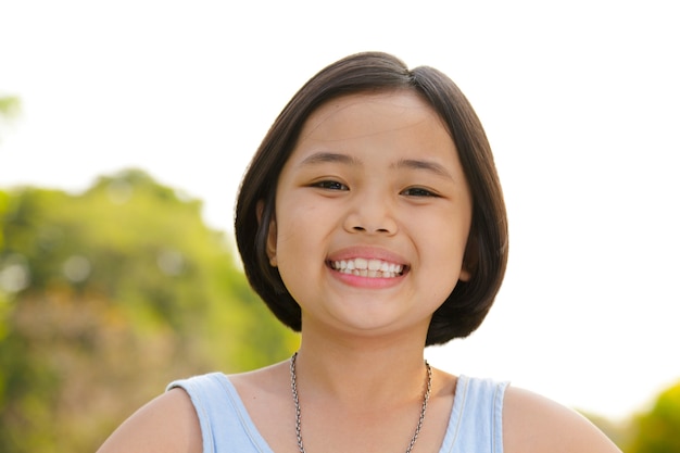 Menina asiática sorrindo alegremente no parque