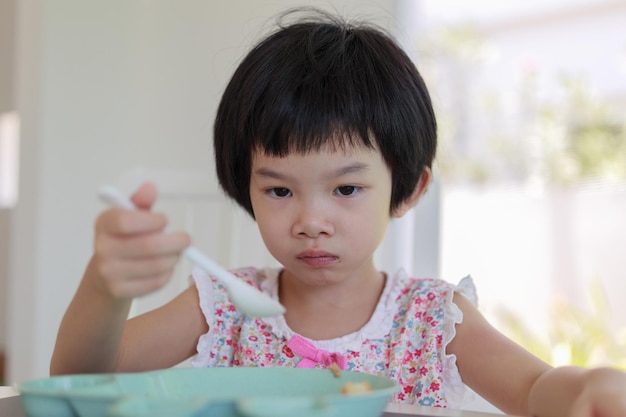 Menina asiática tomando café da manhã