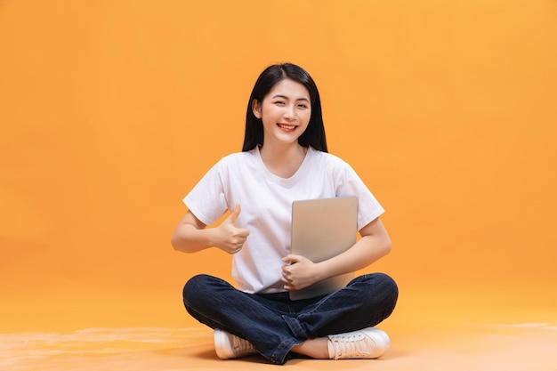 Menina asiática usando laptop no fundo