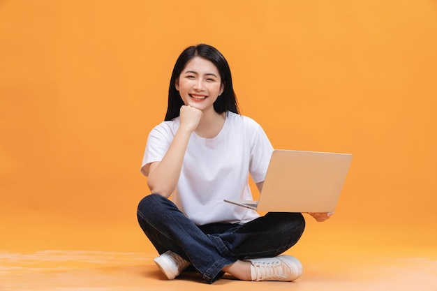 Menina asiática usando laptop no fundo