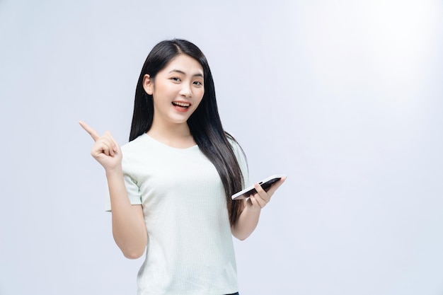 Menina asiática usando smartphone em segundo plano