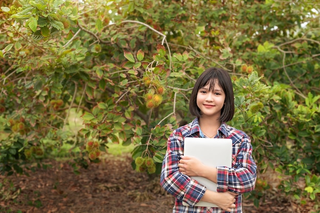 Menina asiática, verificação de frutas orgânicas de relatório