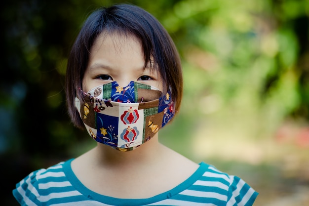Menina asiática viajantes com máscara cirúrgica para proteger o covid-19