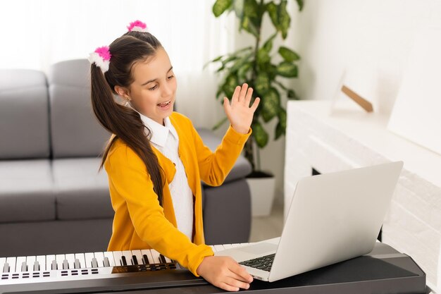 Menina assistindo tutorial de lição on-line como aprender um sintetizador.