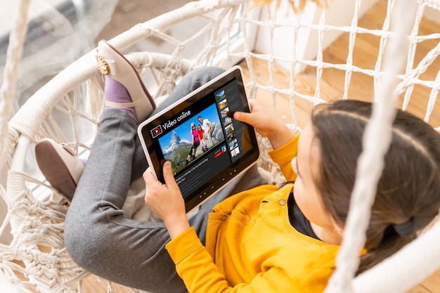 menina assistindo vídeos de viagens online. Criança assistindo a um vídeo sobre a viagem com a família.