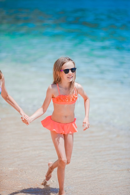 Menina ativa na praia se divertindo à beira-mar