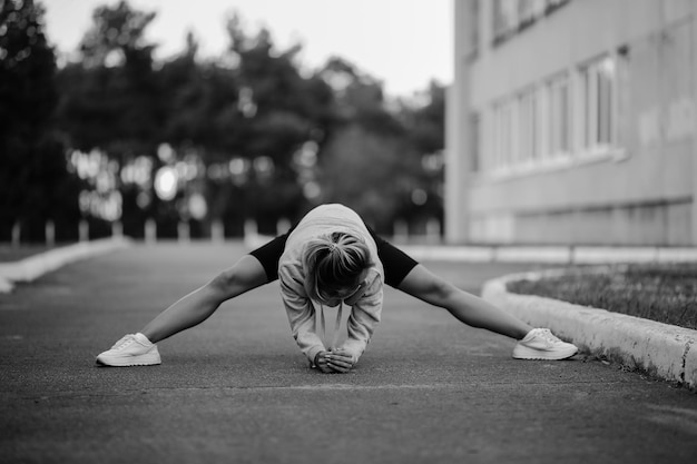 menina atleta envolvida em esportesJovem atlética fazendo exercícios matinais foto preto e branco