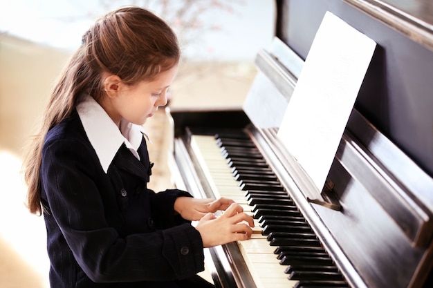 Menina atraente toca piano