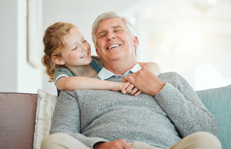 Foto menina avô e relaxar no sofá com sorriso para cuidar de ligação e abraçar no fim de semana com o amor da infância avô filho e feliz juntos na casa da família com abraço afeto e rir no sofá