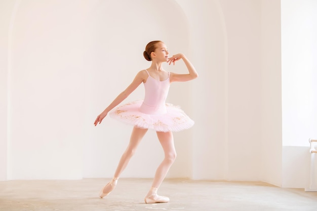 Menina bailarina em tutu aprendendo balé na escola de dança