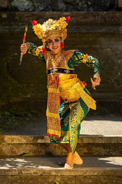 Menina balinesa em vestido tradicional dançando dança balinesa