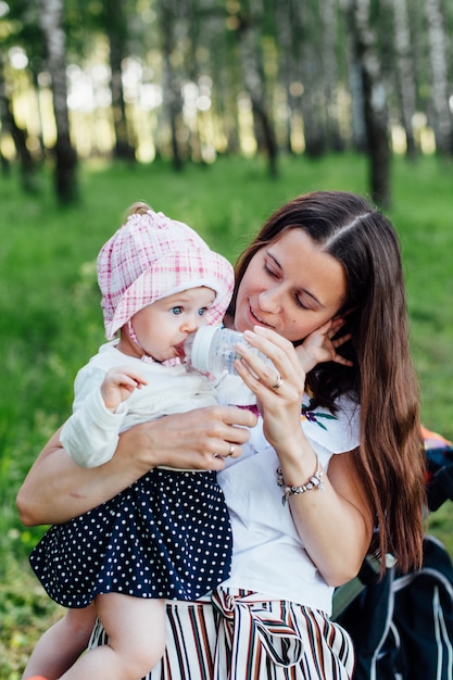 menina bebe água de uma mamadeira