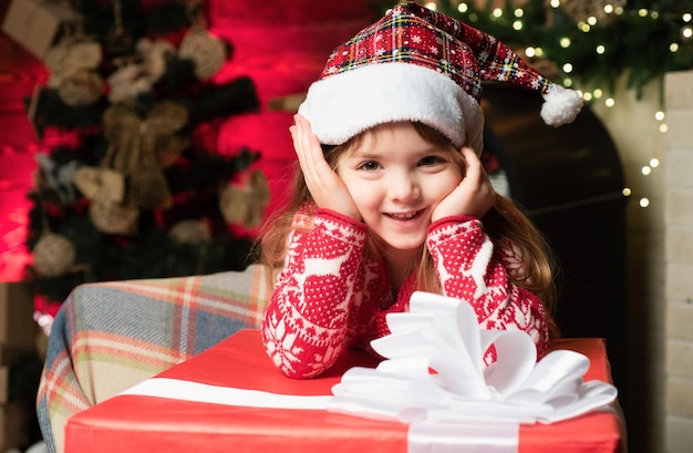 Menina bebê véspera de natal Menina bonitinha brinca perto da árvore de natal Garoto aproveita as férias de inverno em casa Casa cheia de alegria e amor Atmosfera de natal aconchegante Feliz natal e feliz ano novo