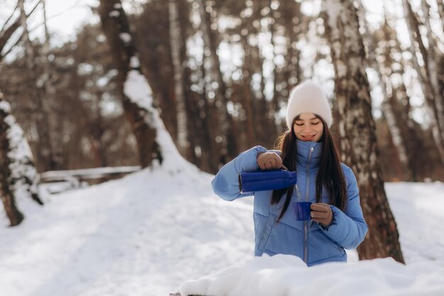 Menina bebendo chá quente na floresta de inverno fecha formato horizontal Foto de alta qualidade