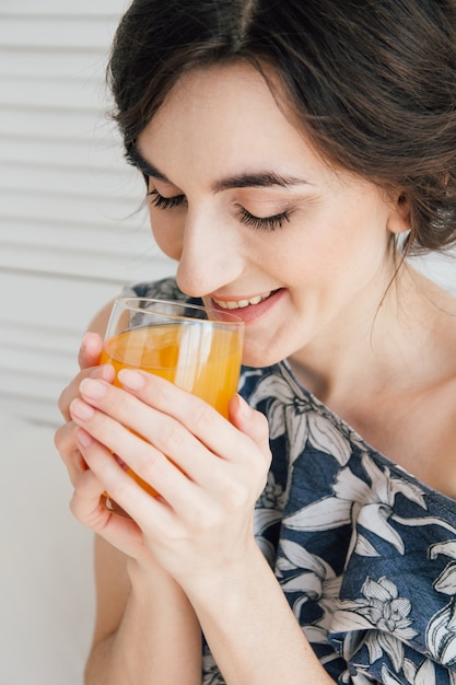 Menina bebendo suco de laranja no café da manhã na cama