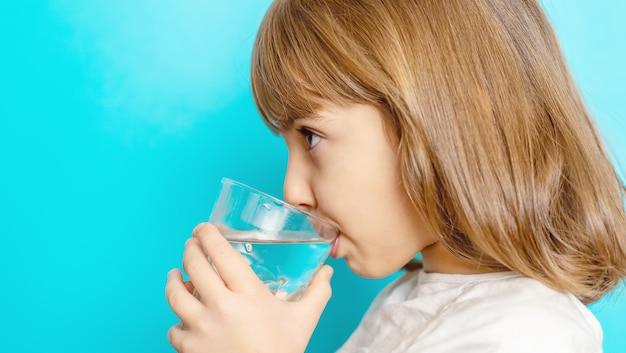 Menina beber água de um copo