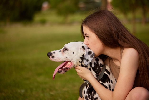 menina beijando cachorro dálmata no parque amor por cachorro e animais