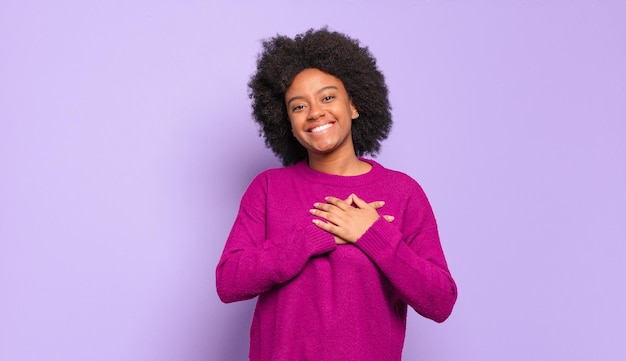 Menina bonita afro contra parede plana