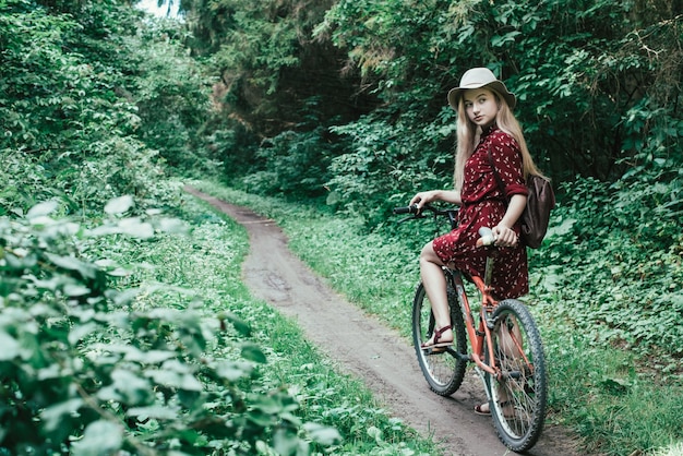 Menina bonita andando de bicicleta através do estilo de vida do parque