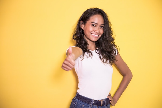 Menina bonita asiática sorrindo enquanto dando os polegares