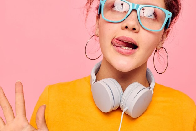 Menina bonita camiseta amarela fones de ouvido entretenimento música diversão fundos isolados inalterados