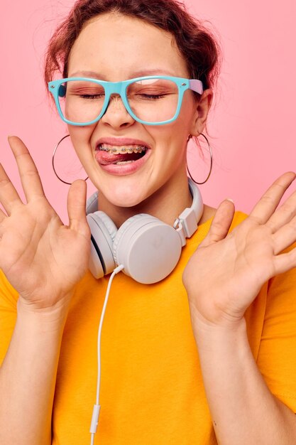 Menina bonita camiseta amarela fones de ouvido entretenimento música diversão fundos isolados inalterados