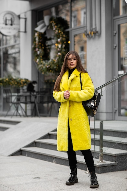 Menina bonita com cabelo comprido com casaco de pele amarelo Conceito de pele e moda Pessoas bonitas