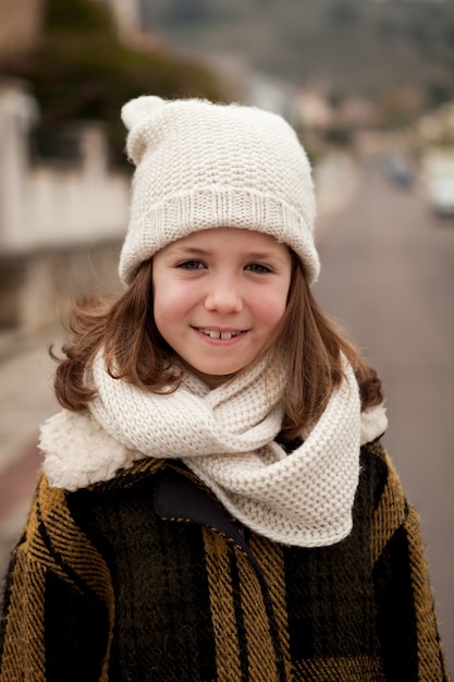 Menina bonita com chapéu de lã em um parque