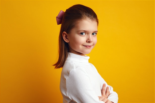 Menina bonita com gola alta branca posando adoravelmente em fundo amarelo