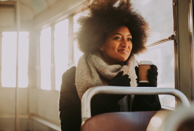 Foto menina bonita com retratos de corte de cabelo afro no transporte público